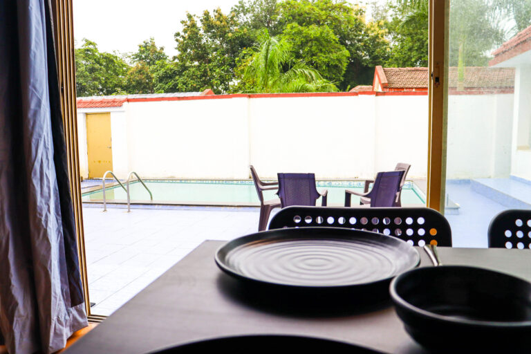 Sihra Villa, Neral: Dining table looking through glass doors to the pool